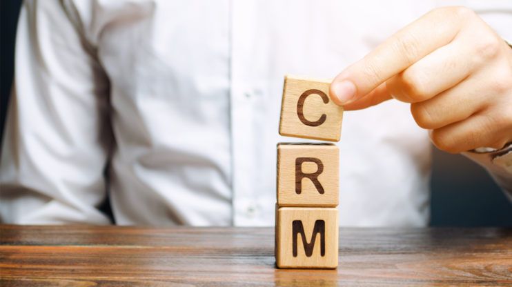 man with three wooden cubes in front of him saying CRM