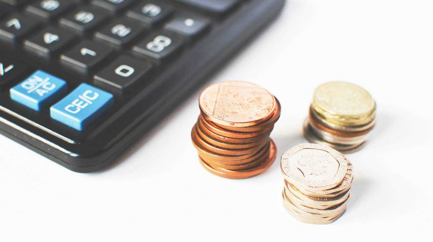 Coins stacked up near a calculator